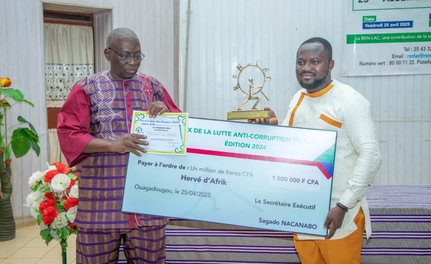 Le représentant de Hervé D'Afrikrecevant le trophée du PLAC 2024 des mains du nouveau Secrétaire exécutif du REN-LAC, Pissyamba Ouédraogo